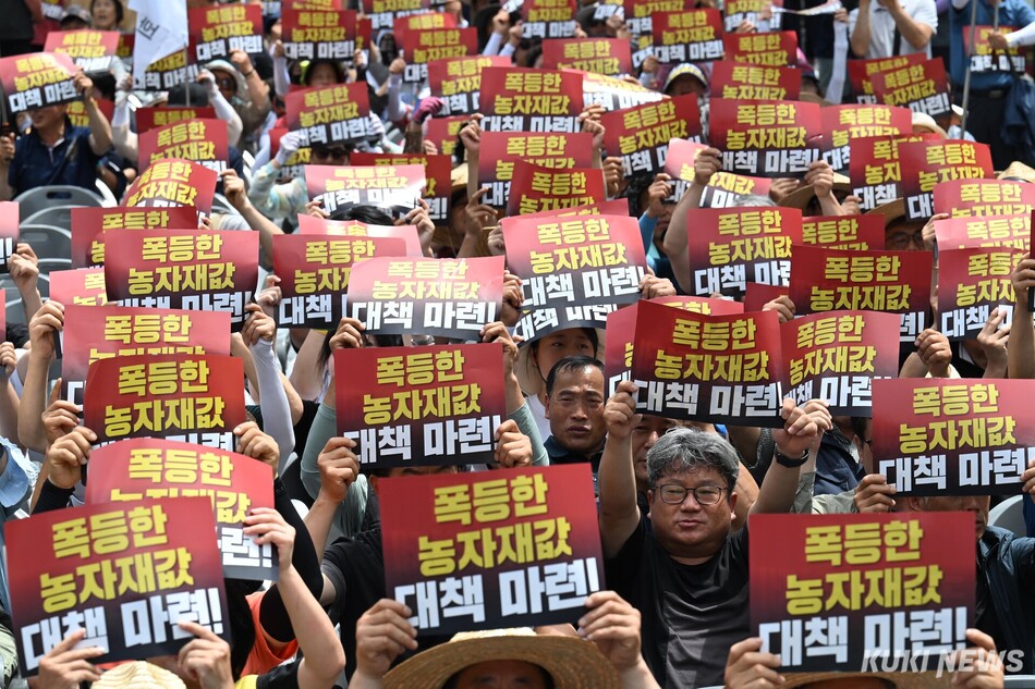 ‘7.7 전국농민대회‘에 참가한 농민들이 7일 오후 서울 광화문 동화면세점 앞에서 손팻말을 들고 있다.